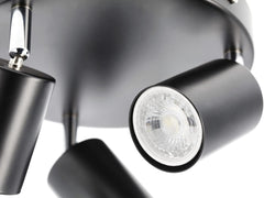Close-up of a modern ceiling light fixture with three black cylindrical lights.