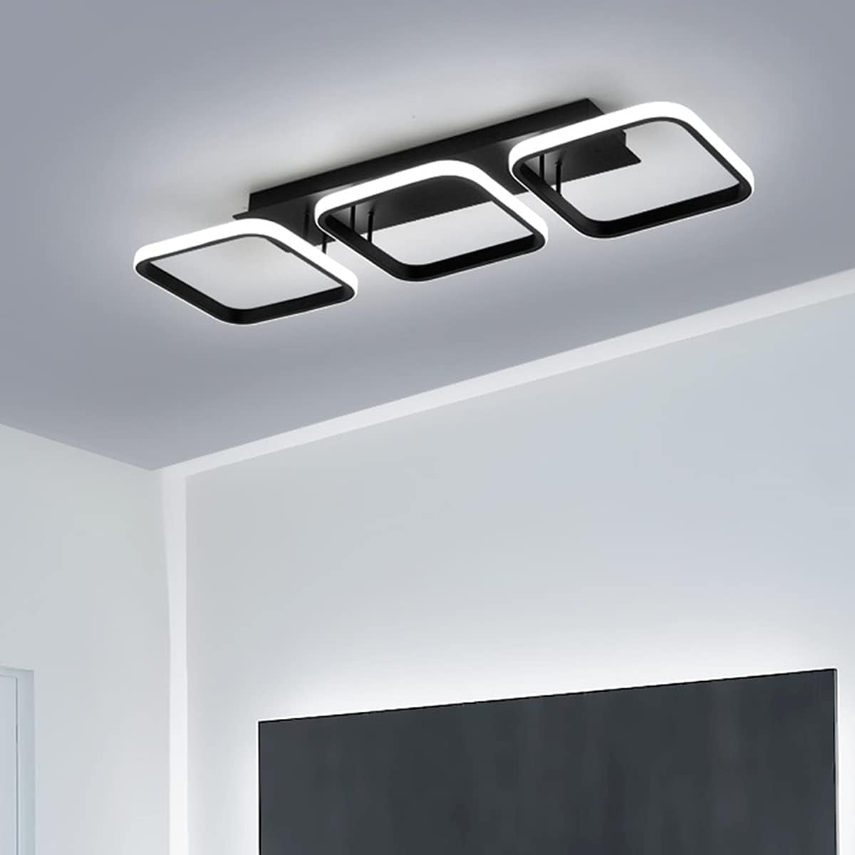 Modern ceiling light fixture in a room with a television.