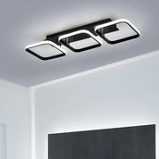 Modern ceiling light fixture in a room with a television.