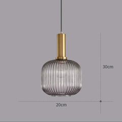 Pendant light with ribbed glass shade and gold fixture on a gray background