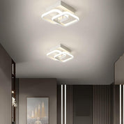 Two modern square ceiling lights on a ceiling with a neutral color scheme.