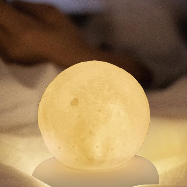 Moon-shaped night light on a soft surface with a blurred background