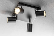 Modern ceiling light fixture with four cylindrical lights on a gray background