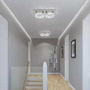 Modern hallway with ceiling lights, bookshelf, and framed pictures.