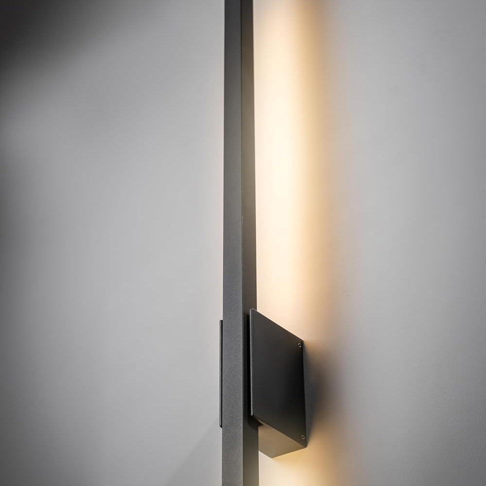 Modern wall-mounted light fixture on a gray wall