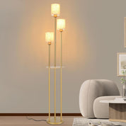Gold floor lamp with two light bulbs in a room setting.
