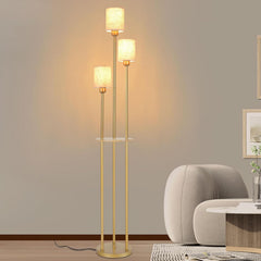 Gold floor lamp with two light bulbs in a room setting.