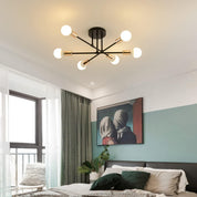 Modern ceiling light fixture in a bedroom with a bed and artwork on the wall.