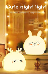 Two cute rabbit-shaped night lights on a surface with a blurred background.