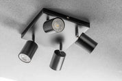 Modern ceiling light fixture with four cylindrical lights on a gray background