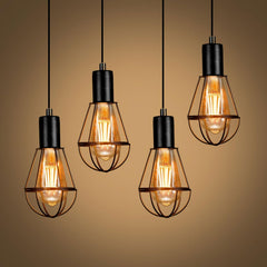 Four vintage-style light bulbs hanging against a brown background