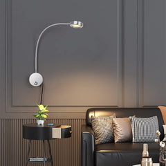 Modern living room with a black sofa, side table, and wall-mounted lamp.