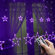 Star-shaped LED string lights with a remote control in front of a window.