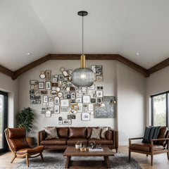 Living room with brown leather sofa, armchairs, and a wall of framed pictures.