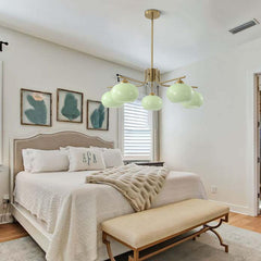 Modern bedroom with a chandelier, bed, and bench.