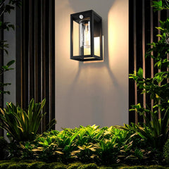 Outdoor wall light fixture on a garden wall with plants around