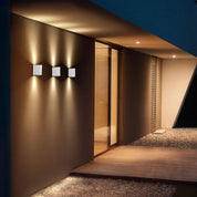 Modern architectural design with wall lights and glass doors at night.