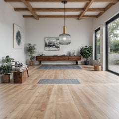Modern living room with wooden floor, ceiling beams, and large windows.