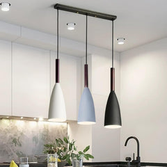 Three pendant lights in white, blue, and black hanging above a kitchen counter.