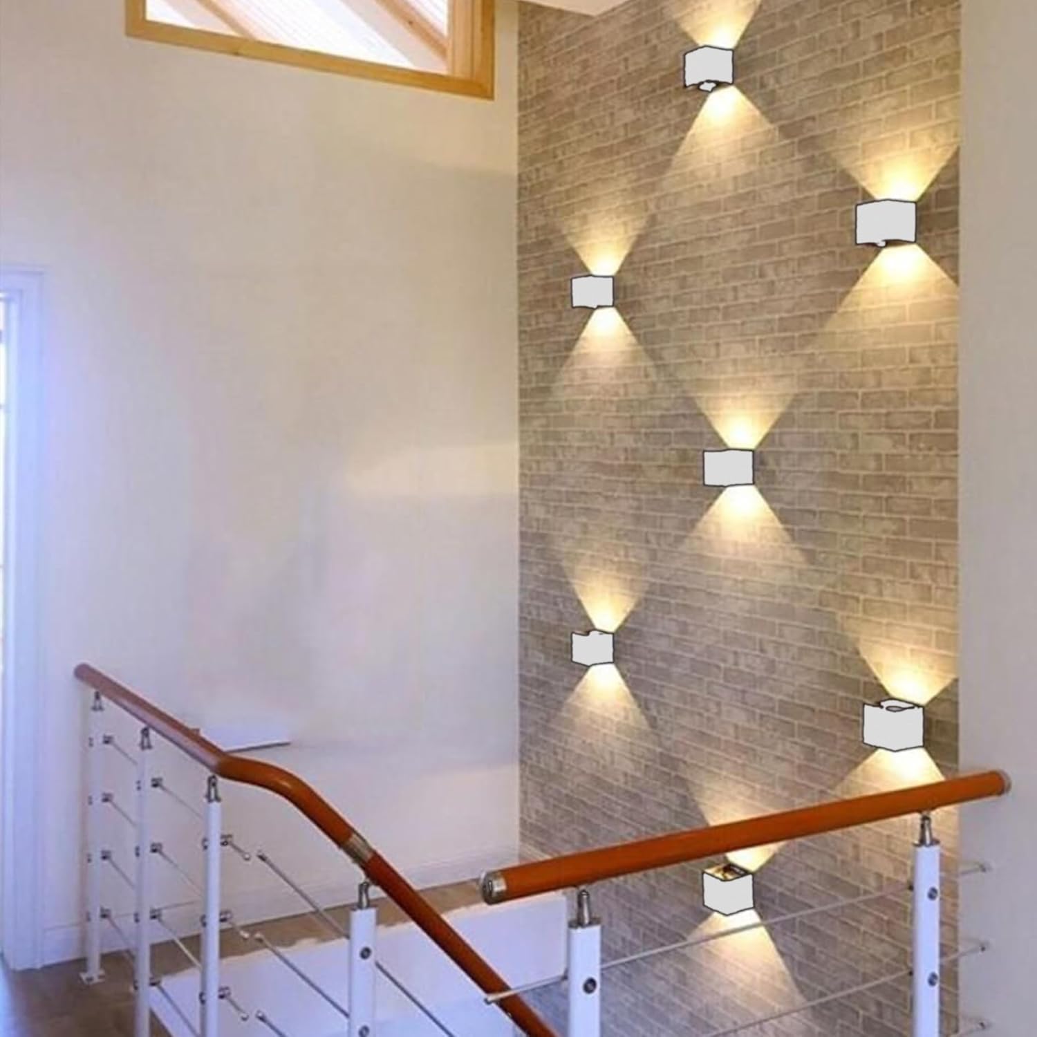 Stairwell with wooden handrail and wall-mounted lights on a textured wall.