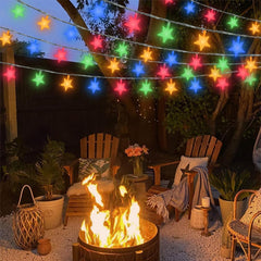 Outdoor setting with a fire pit, chairs, and colorful string lights in a garden.