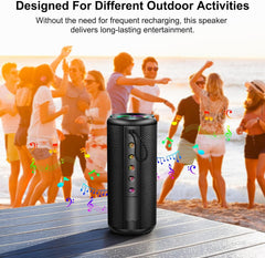 Black portable speaker on a wooden surface with people dancing in the background at a beach.