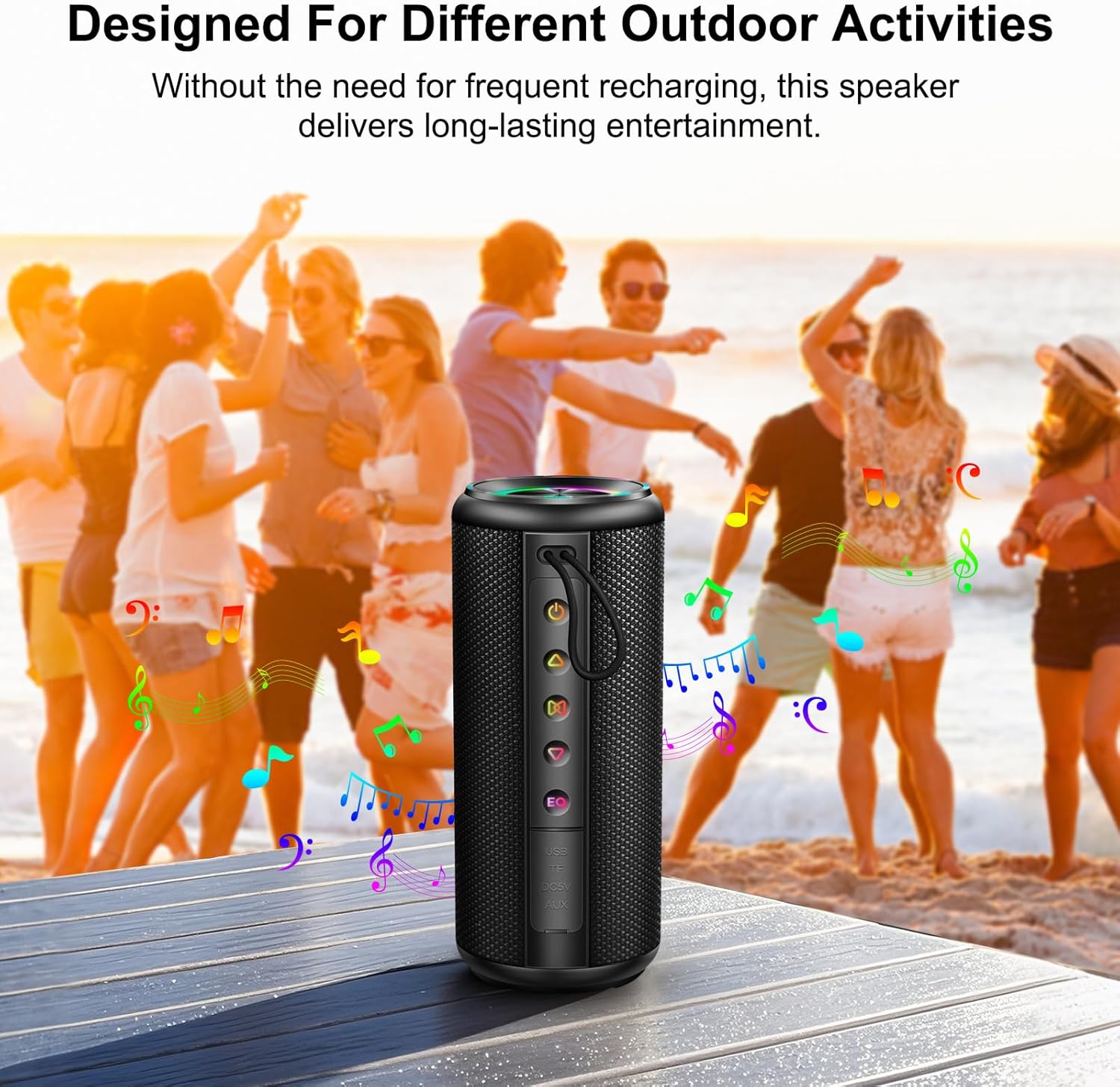 Black portable speaker on a wooden surface with people dancing in the background at the beach.