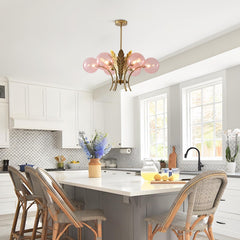 Modern kitchen with white cabinets, a chandelier, and a dining area.