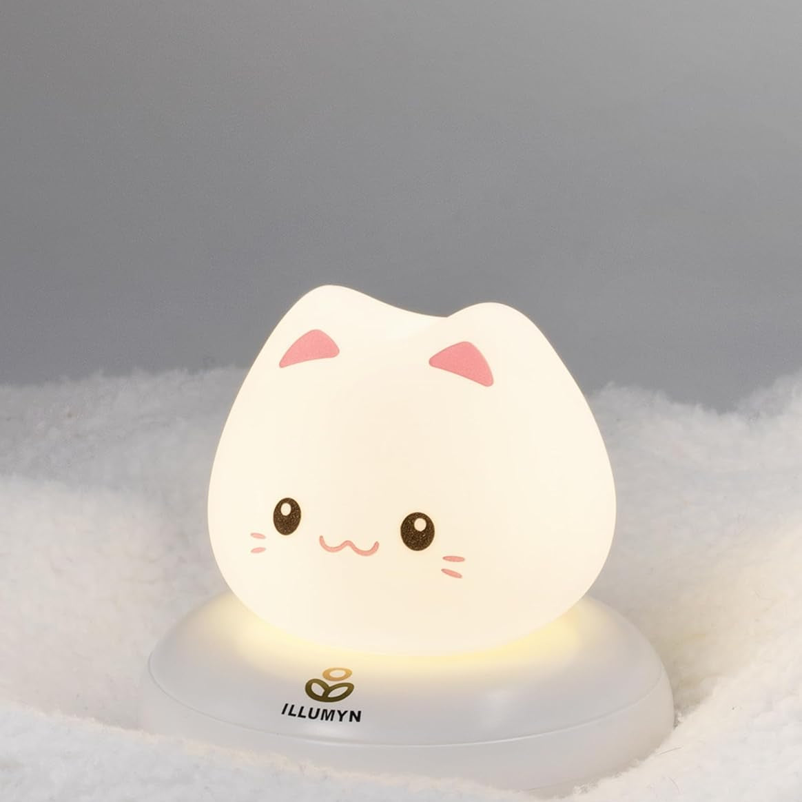 Cute cat-shaped night light on a soft surface with a gray background