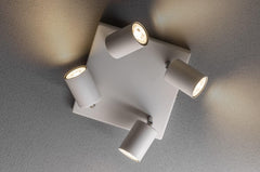 Ceiling light fixture with four cylindrical lights on a gray ceiling