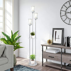 Living room with a gray sofa, floor lamp, plant, and wooden console table.