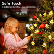 Child decorating a Christmas tree with safe touch decorations.