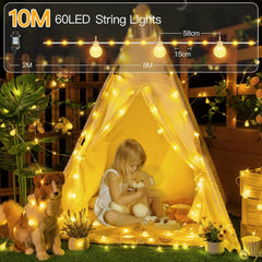 Child playing with a teddy bear inside a tent illuminated by 60 LED string lights, with a dog nearby.