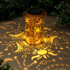 Decorative solar lantern casting patterns on the ground with greenery around.