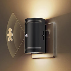 Black wall-mounted light fixture with motion sensor on a beige wall.