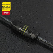 Black waterproof cable connector with IP68 rating on a wet surface