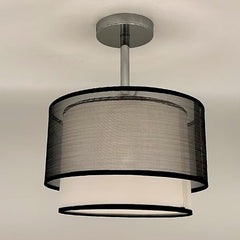Ceiling light fixture with black and white shade on a neutral background