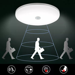 Ceiling light fixture with shadow projection of a person walking, on a dark background.