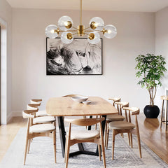 Dining room with a modern chandelier, wooden table, and chairs.