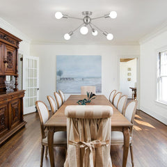 Dining room with wooden table and chairs, wooden sideboard, and ceiling light fixture.