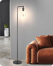 Floor lamp with a modern design next to a brown sofa in a room.