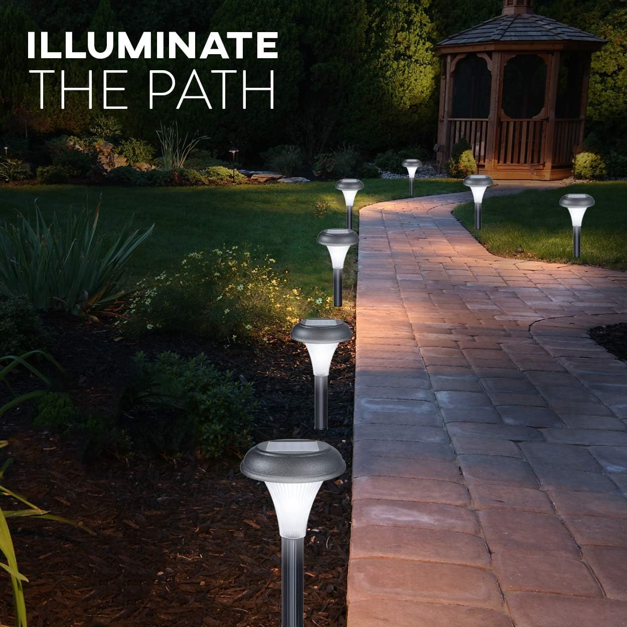 Garden pathway illuminated by solar lights with a gazebo in the background.