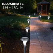 Garden pathway illuminated by solar lights with a gazebo in the background.
