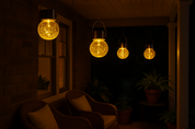 Glowing spherical outdoor lights hanging above a patio area at night.