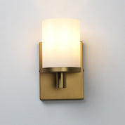 Gold wall sconce with a white glass shade on a light gray background