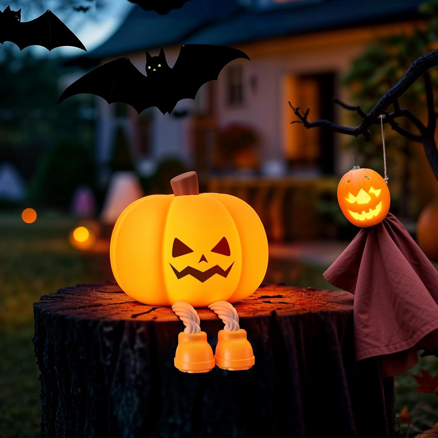 Halloween-themed decoration with a jack-o'-lantern on a stump, bats, and a ghost in the background.