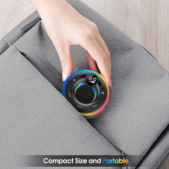 Hand placing a compact, portable device with a digital display on a gray surface.