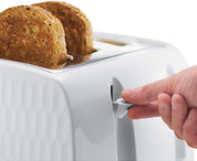 Hand pressing a button on a white toaster with two slices of bread inside.