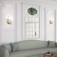 Living room with gray sofa, decorative pillows, and wall sconces.