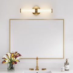Modern bathroom setup with a gold-framed mirror, sink, and decorative elements.